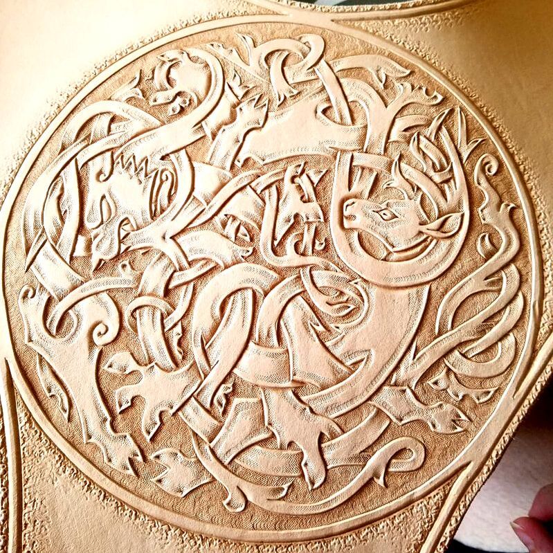 Close up of tooled Celtic stag and wolf.